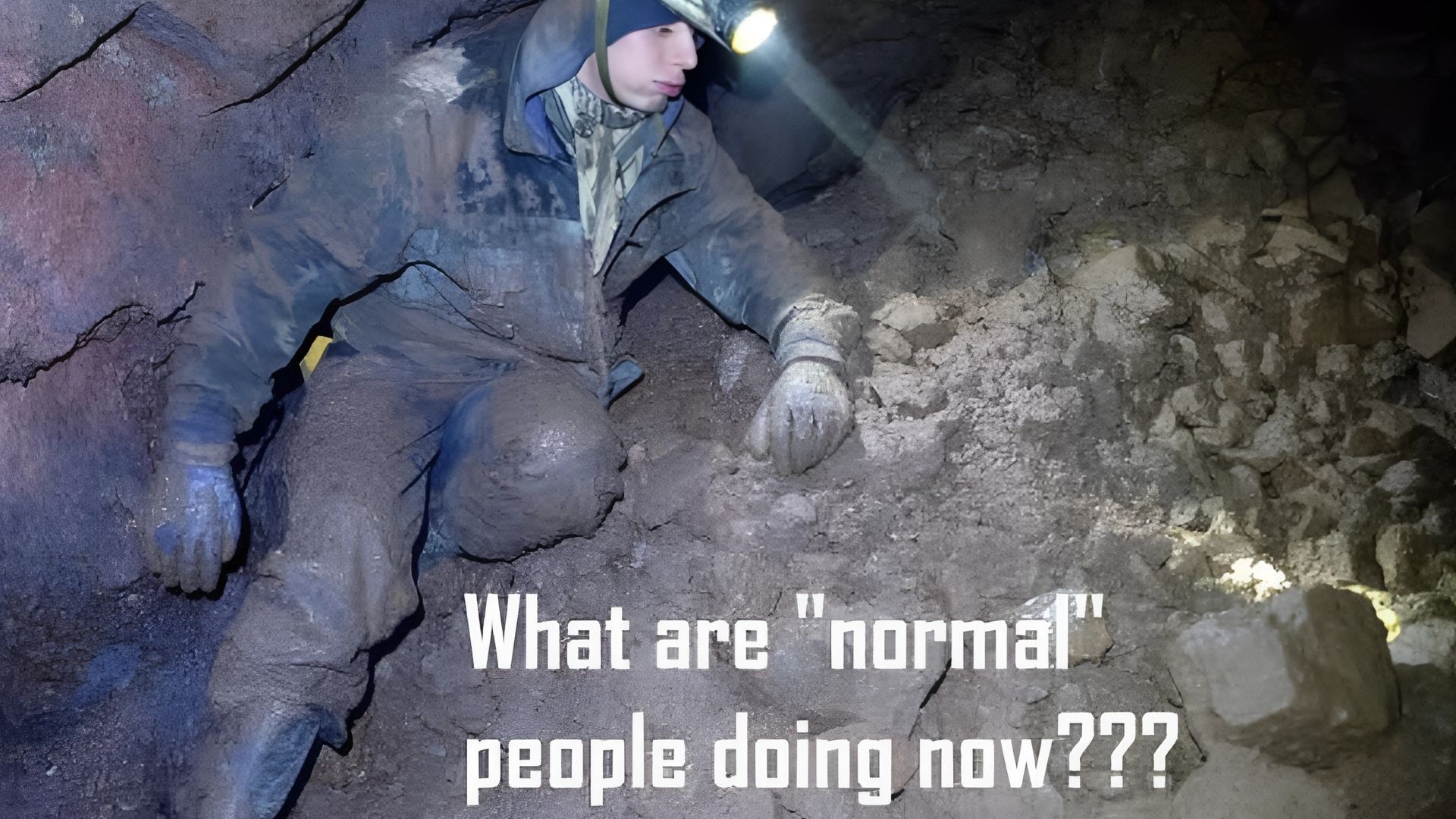 Person crawling in a dark cave, headlamp on, covered in mud. Text: 