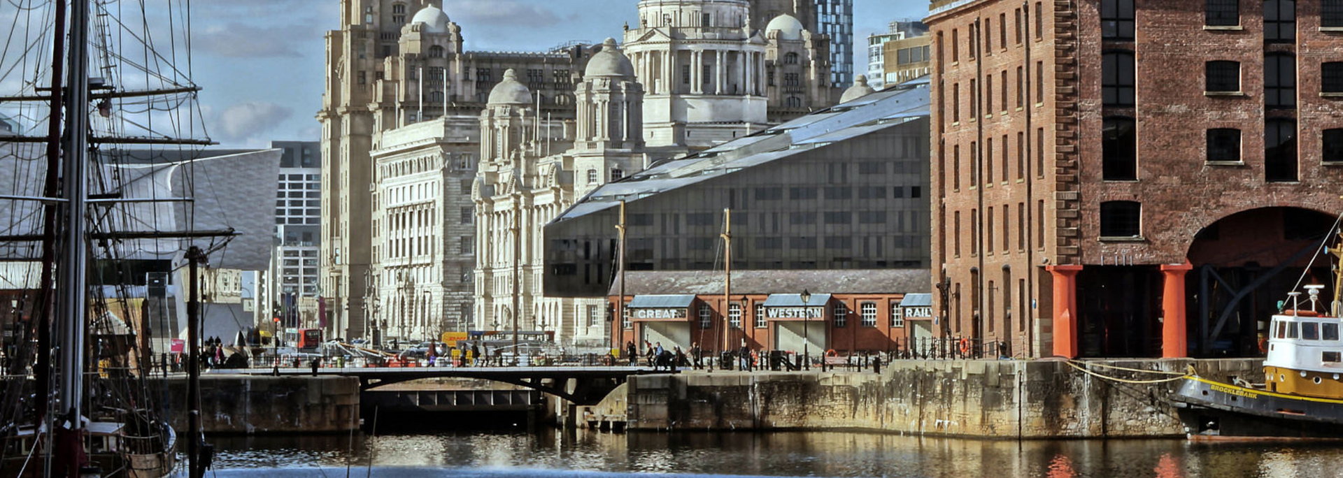 Liverpool waterfront with historic buildings and water.