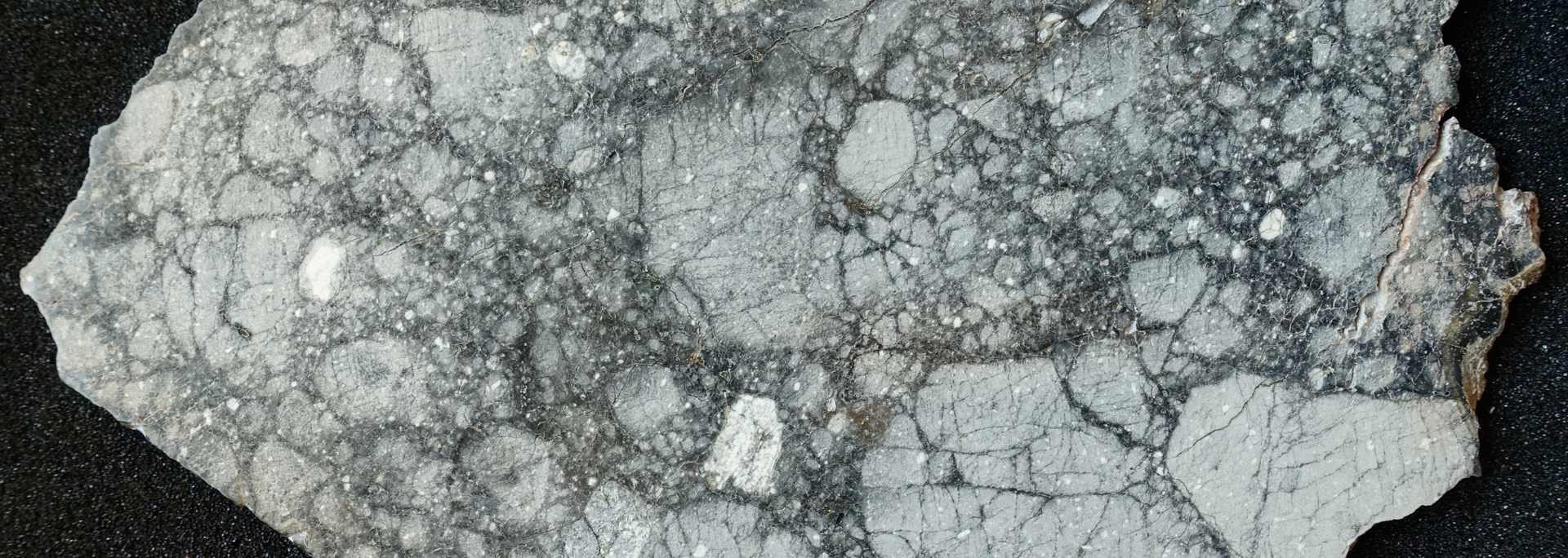 Fragmented, gray and white rock with visible cracks.