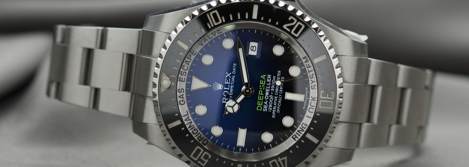 A close-up of a Rolex watch with a blue face, black bezel, and a silver bracelet.