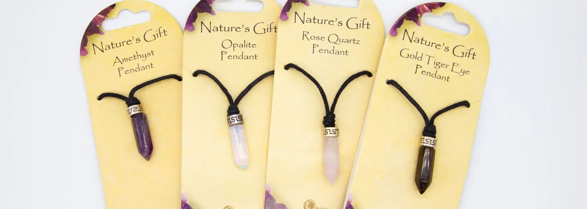 Four crystal pendants on cream-colored tags, labeled 