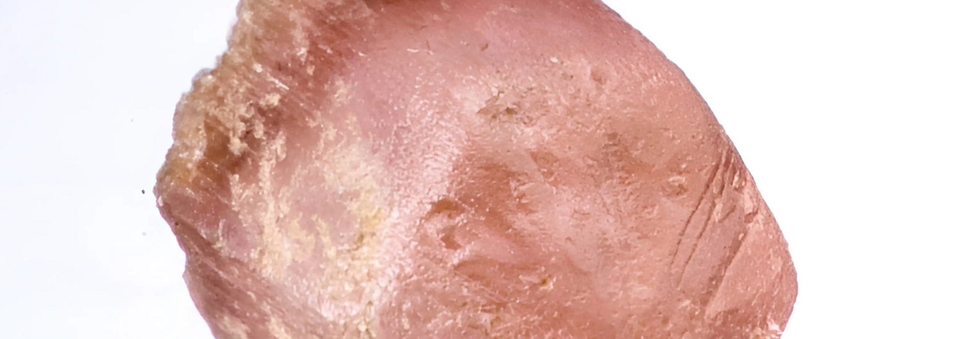 A translucent pink gemstone against a white background.