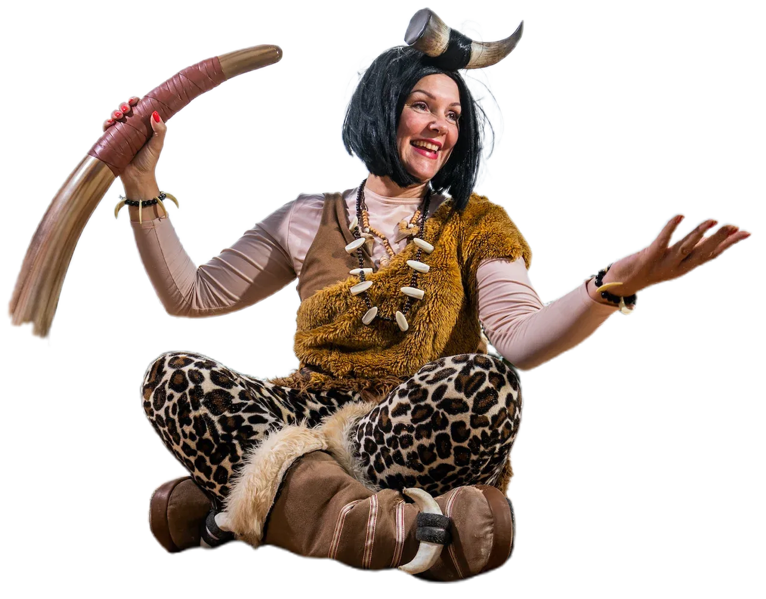 Woman in cavewoman costume holding a bone, wearing horns, and gesturing.