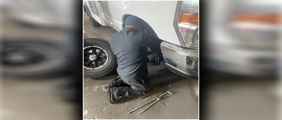 A mechanic doing a wheel alignment | Alpine Automotive Service
