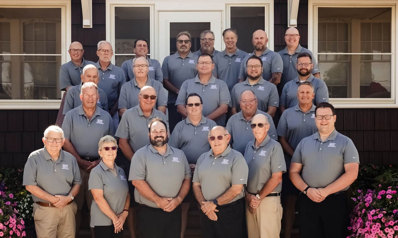 Group of people in blue shirts stand in front of the Steele Saloon.