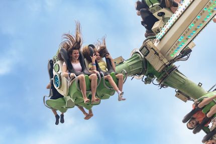 Fair with colorful Monkey Maze ride and crowd.