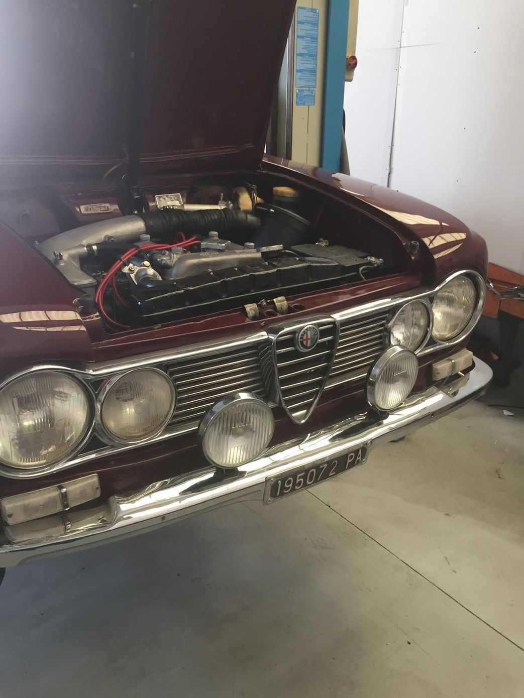 Un'auto nera è su un ascensore con il cofano alzato