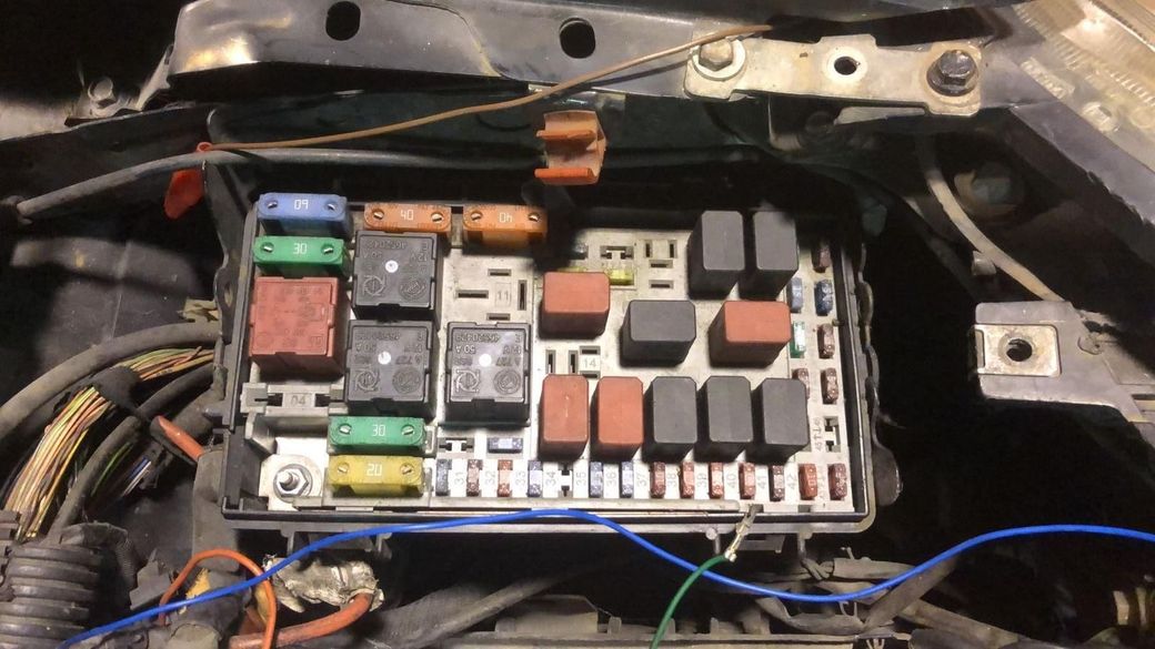 Il motore di una bmw bianca viene rimosso dall'auto.