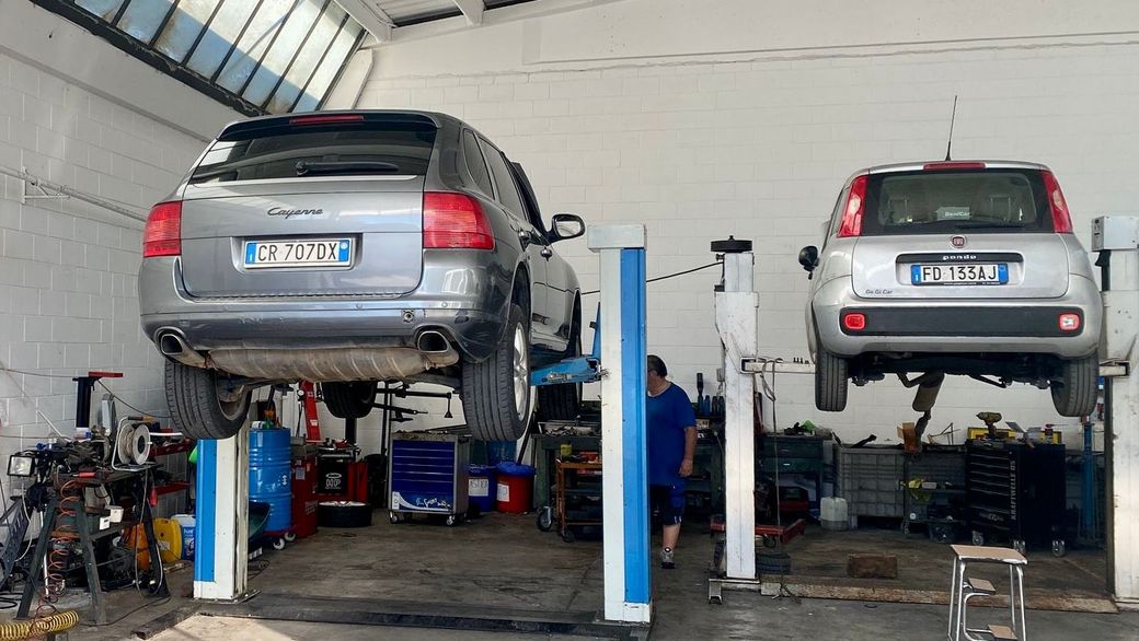 Due auto sono parcheggiate su un elevatore in un garage.