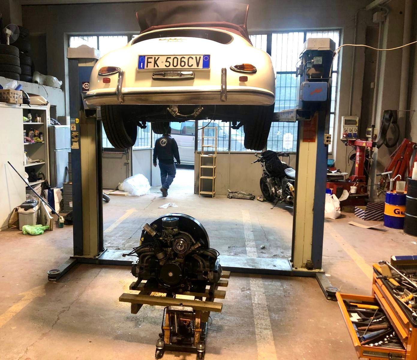 Un'auto con targa fk 506cy è su un ponte sollevatore in un garage.