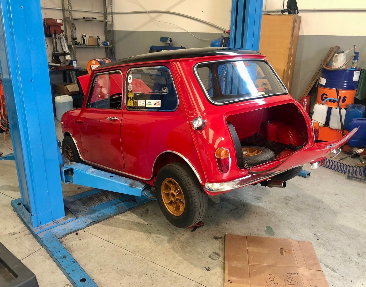 Una mini cooper rossa è su un ascensore in un garage
