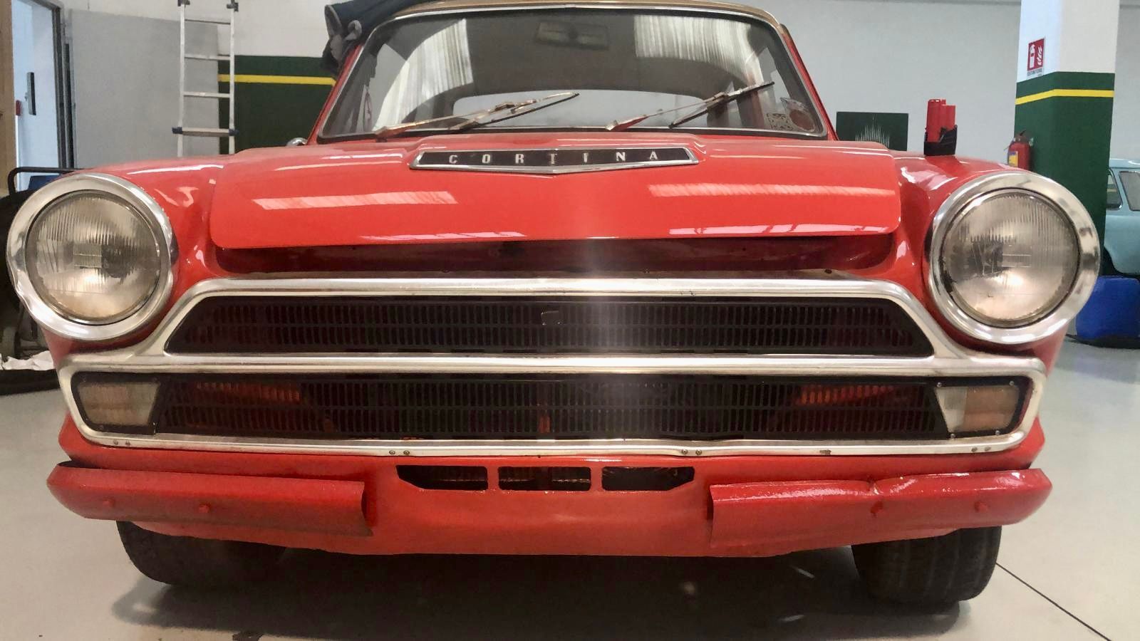La parte anteriore di un'auto rossa è parcheggiata in un garage.