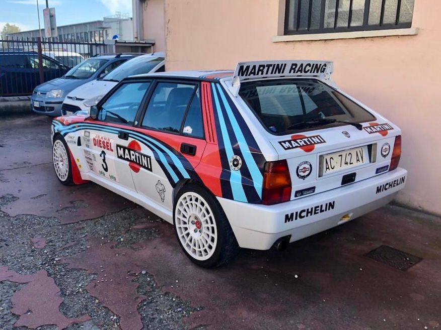 Un'auto da corsa Martini è parcheggiata davanti a un edificio.