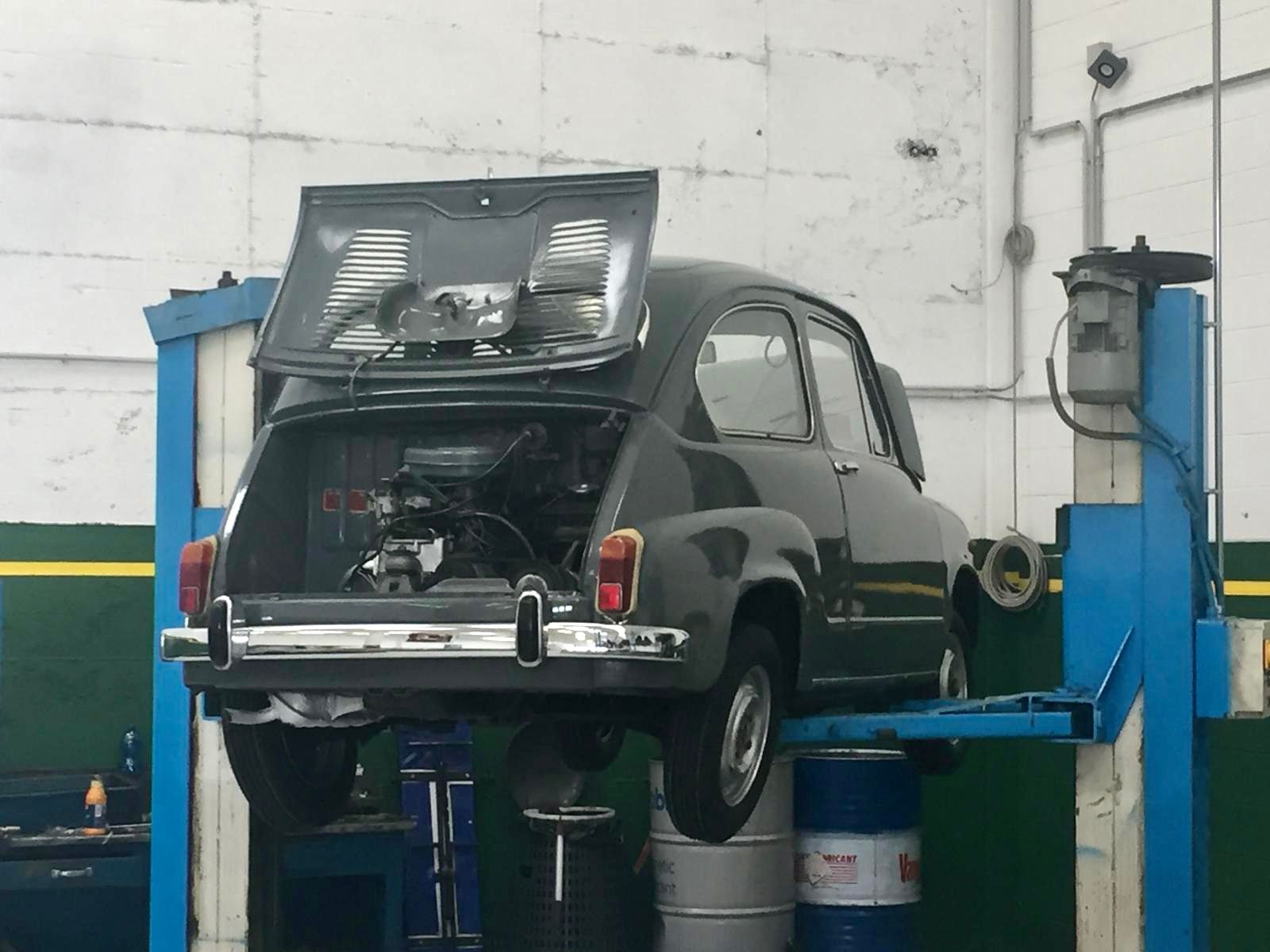 Un'auto nera è su un ascensore con il cofano alzato