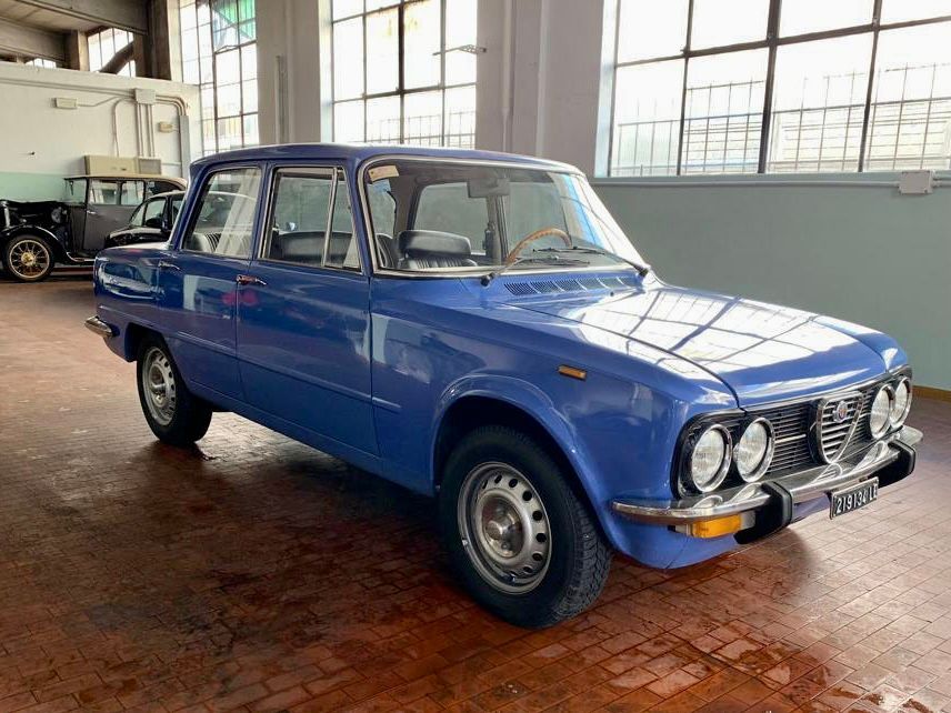 Un'auto blu è parcheggiata in un garage accanto a una finestra.
