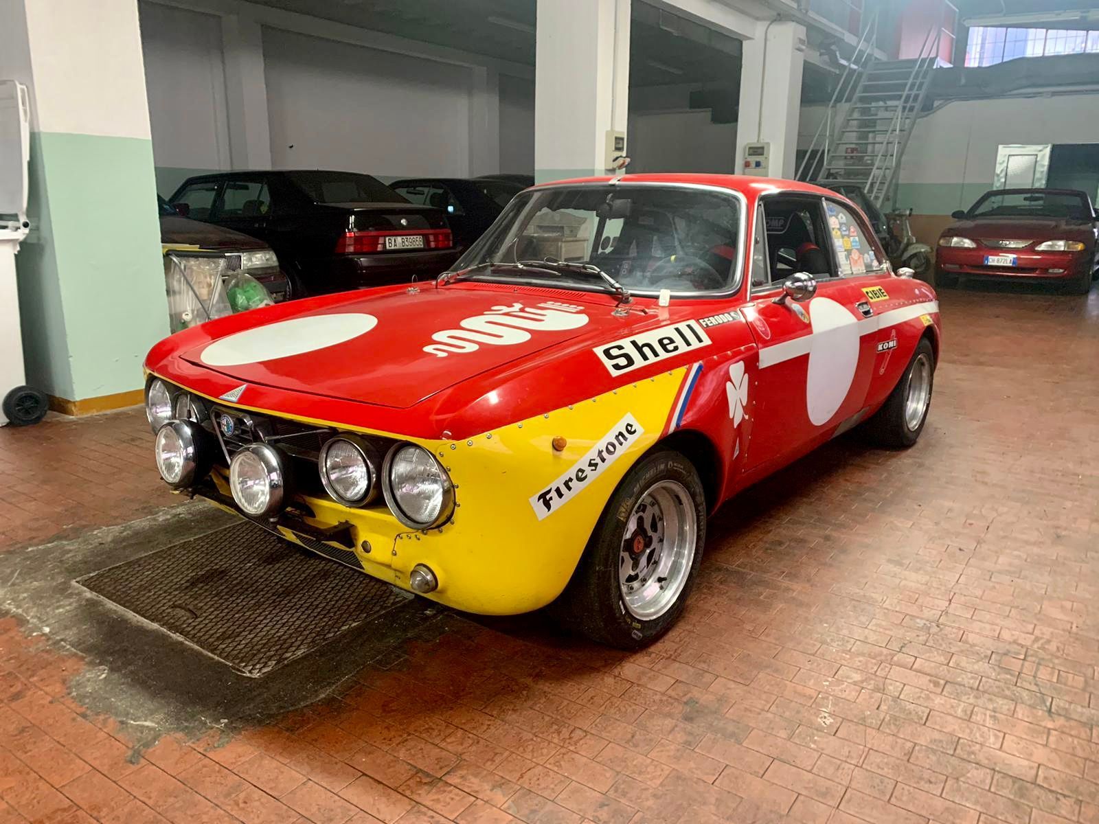Un'auto sportiva rossa e gialla è parcheggiata in un garage.