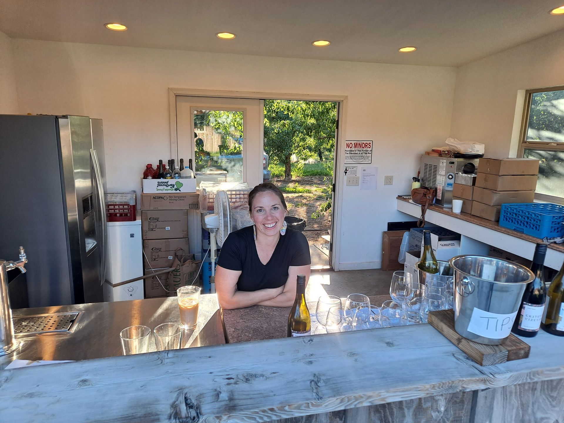 A woman is sitting at a counter in a kitchen.