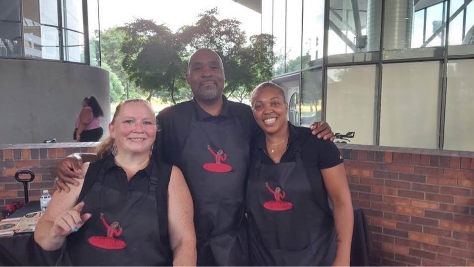 A man and two women wearing aprons are posing for a picture.
