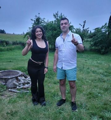 A man and a woman are standing next to each other in a grassy field