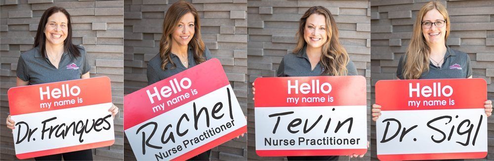 Four smiling healthcare professionals holding name tags.