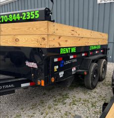 Black utility trailer with wooden sides and green