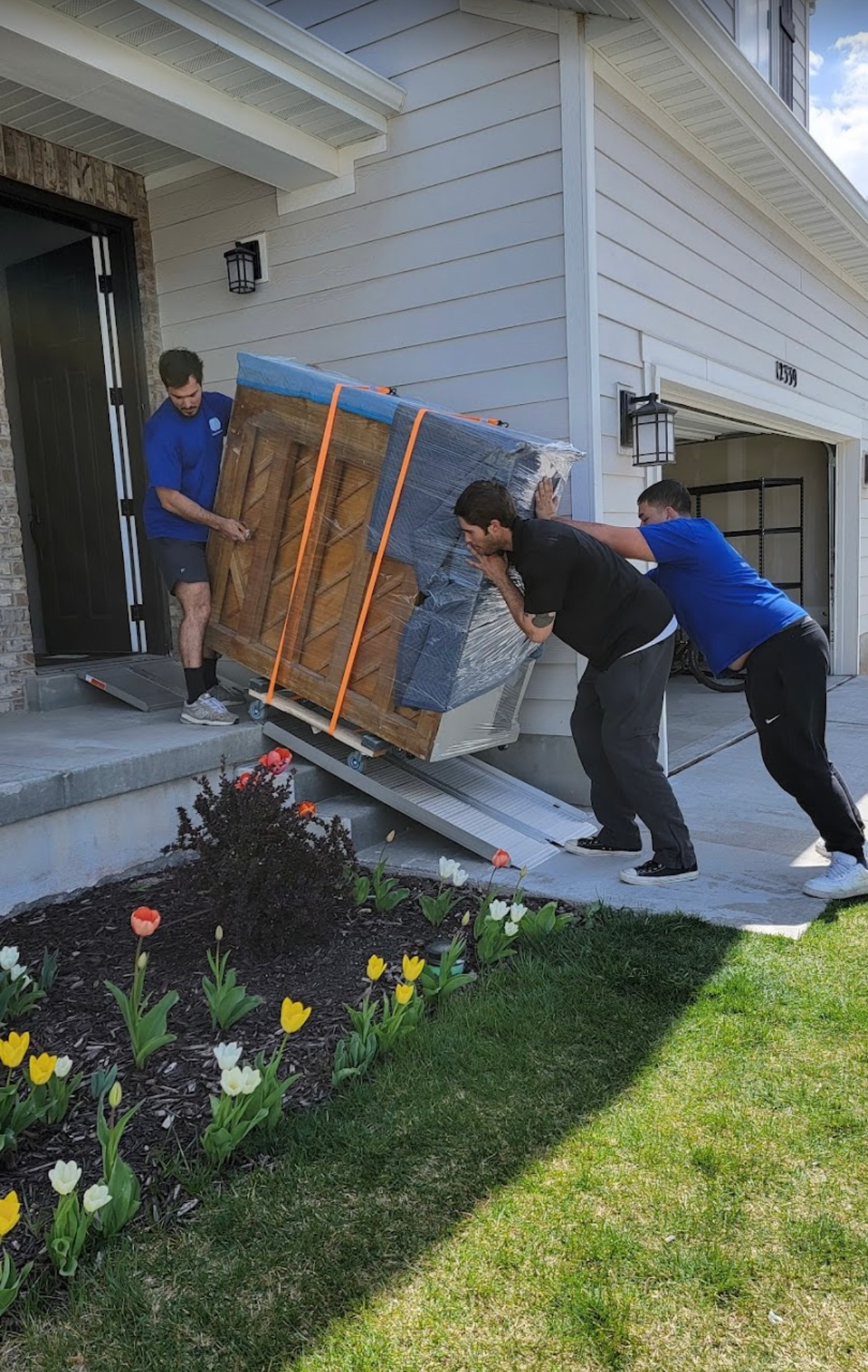 a man is lifting a couch in a living room surrounded by cardboard boxes .