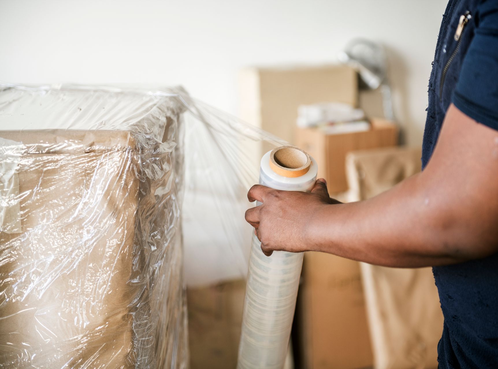 a man is wrapping a box in plastic wrap .