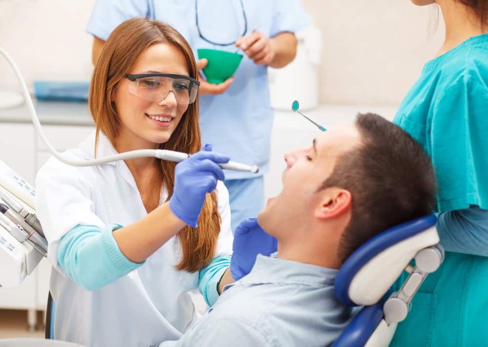 A Dentist Is Examining A Patient's Teeth In A Dental Office — Mittagong Dental Care In Mittagong, NSW