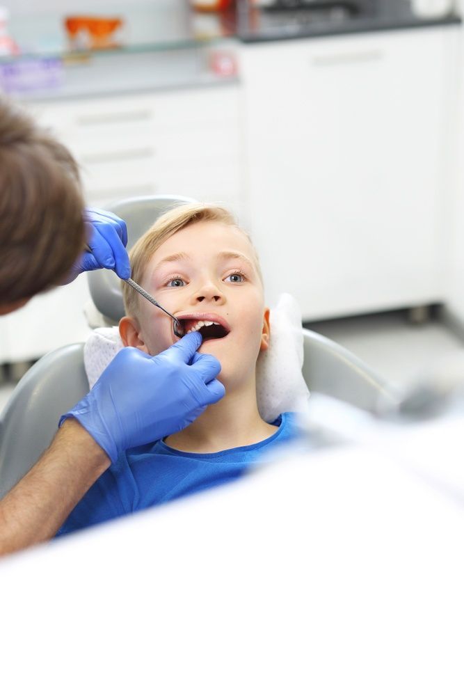 A Young Boy is Sitting in a Dental Checkup — Mittagong Dental Care In Mittagong, NSW