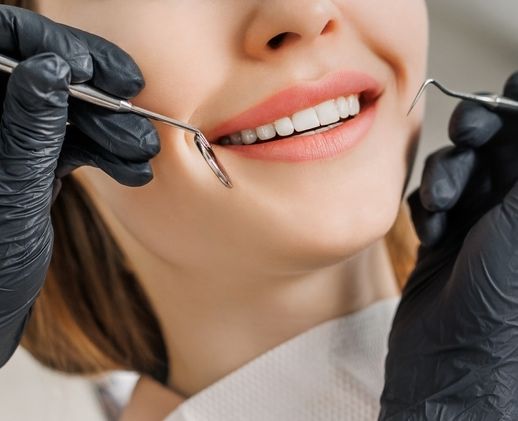A Woman Is Getting Her Teeth Examined By A Dentist — Mittagong Dental Care In Mittagong, NSW