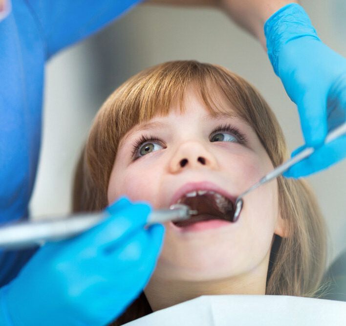 A Child Is Getting His Teeth Examined By A Dentist — Mittagong Dental Care In Mittagong, NSW