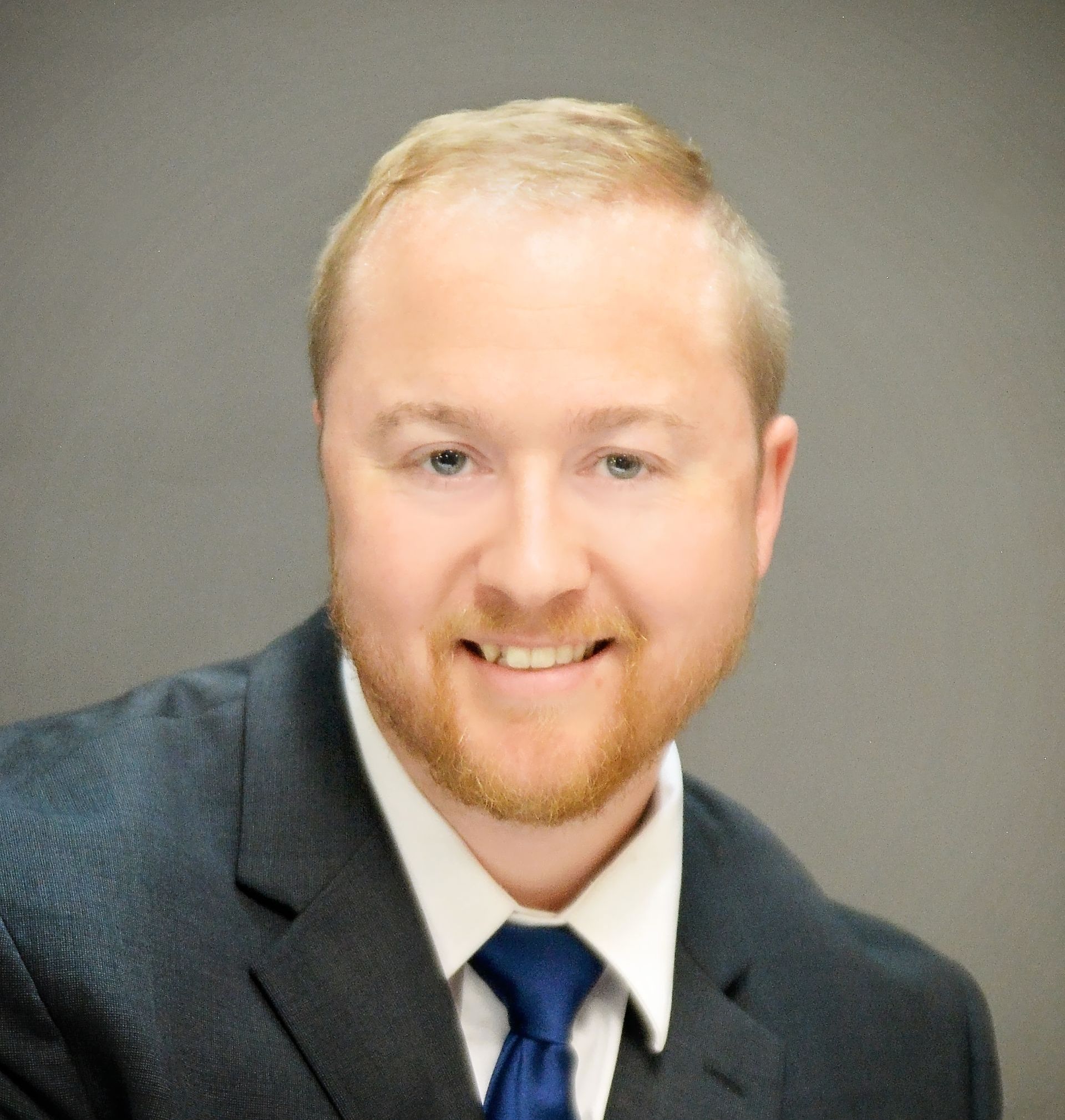 Greetings! I’m Jake Woods, a dedicated professional with a passion for serving and educating customers in the realm of insurance. With six years of experience in the insurance industry, I have cultivated a deep understanding of the intricacies involved in protecting individuals and businesses against unforeseen risks. Portrait of a smiling person in a dark suit and blue tie against a neutral gray background