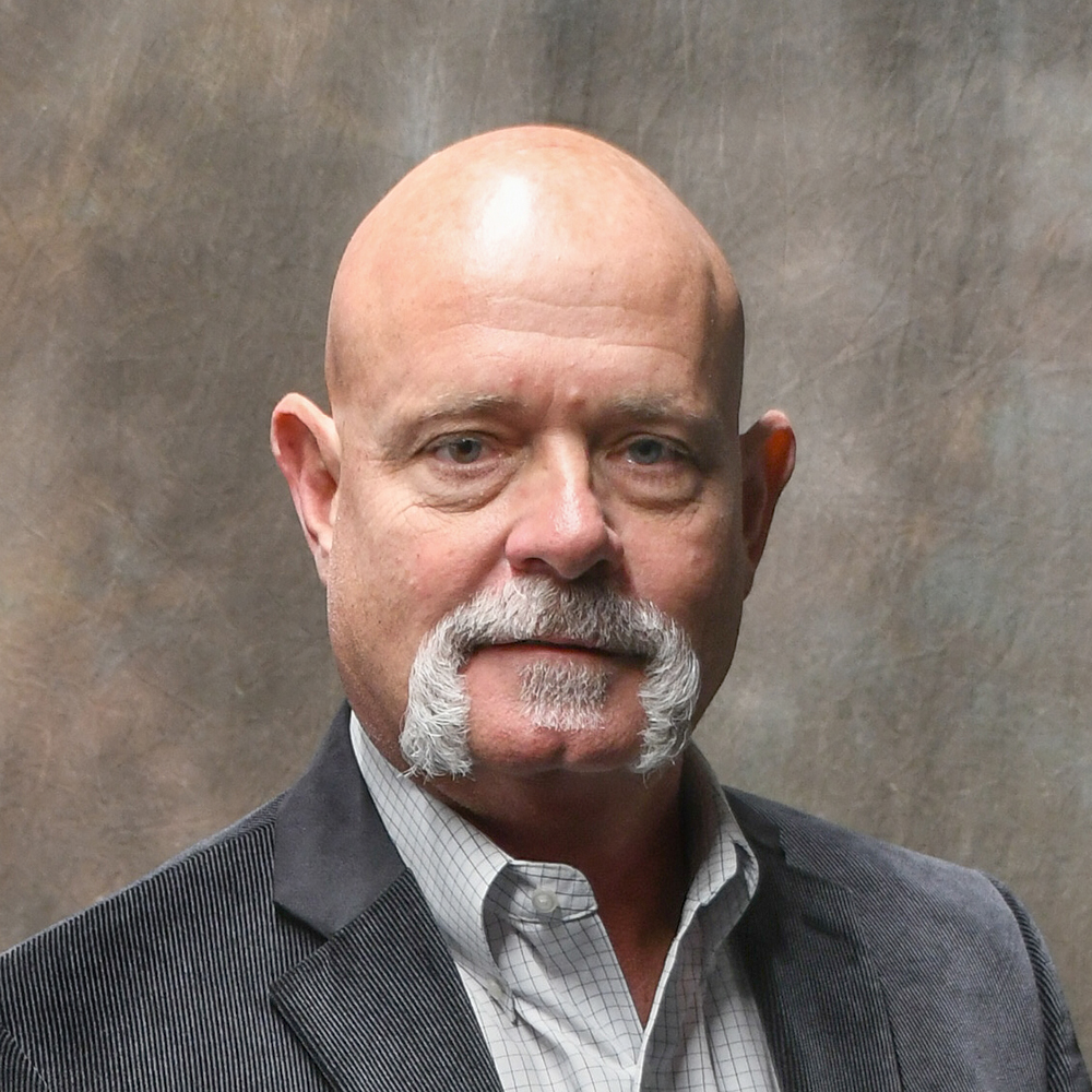 Hi, I'm Todd Dreysse. I'm a licensed, multi-line insurance agent, which means I can meet all your insurance needs. With me as your agent, you can make just one phone call and I'll handle your entire insurance program. Portrait of a bald man with a gray mustache and goatee in a dark blazer against a textured backdrop
