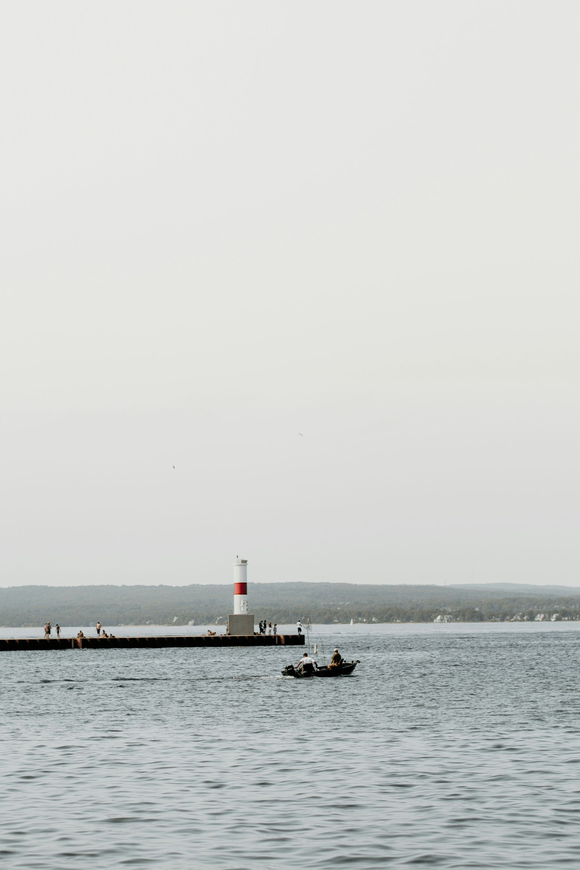 Boat on the water with a lighthouse in the background at Petoskey, Michigan