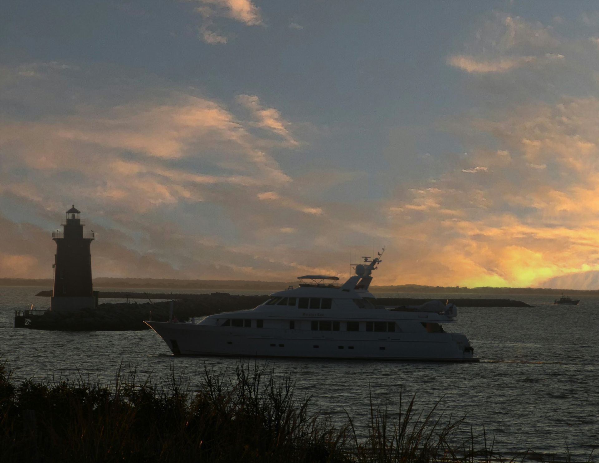 Boat anchored in the bay near a lighthouse at Cape Henlopen State Park in Lewes, Delaware