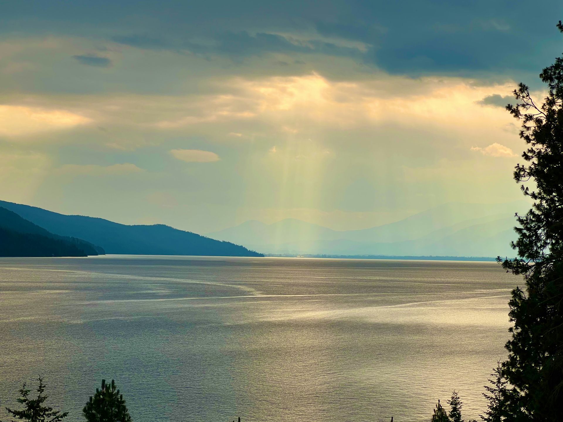 Sun shining through clouds over the water of Lake Pend Oreille, Idaho