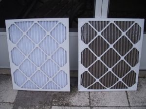Clean and dirty air filters side by side; clean filter is white, dirty filter is dark brown.