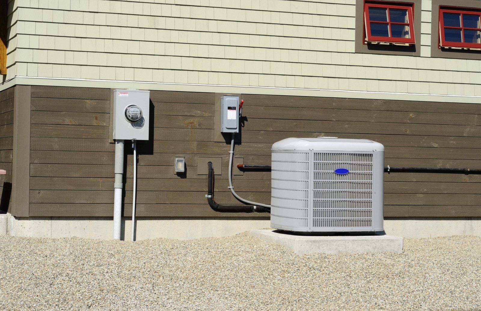 Air conditioning unit outside a building with electrical boxes.