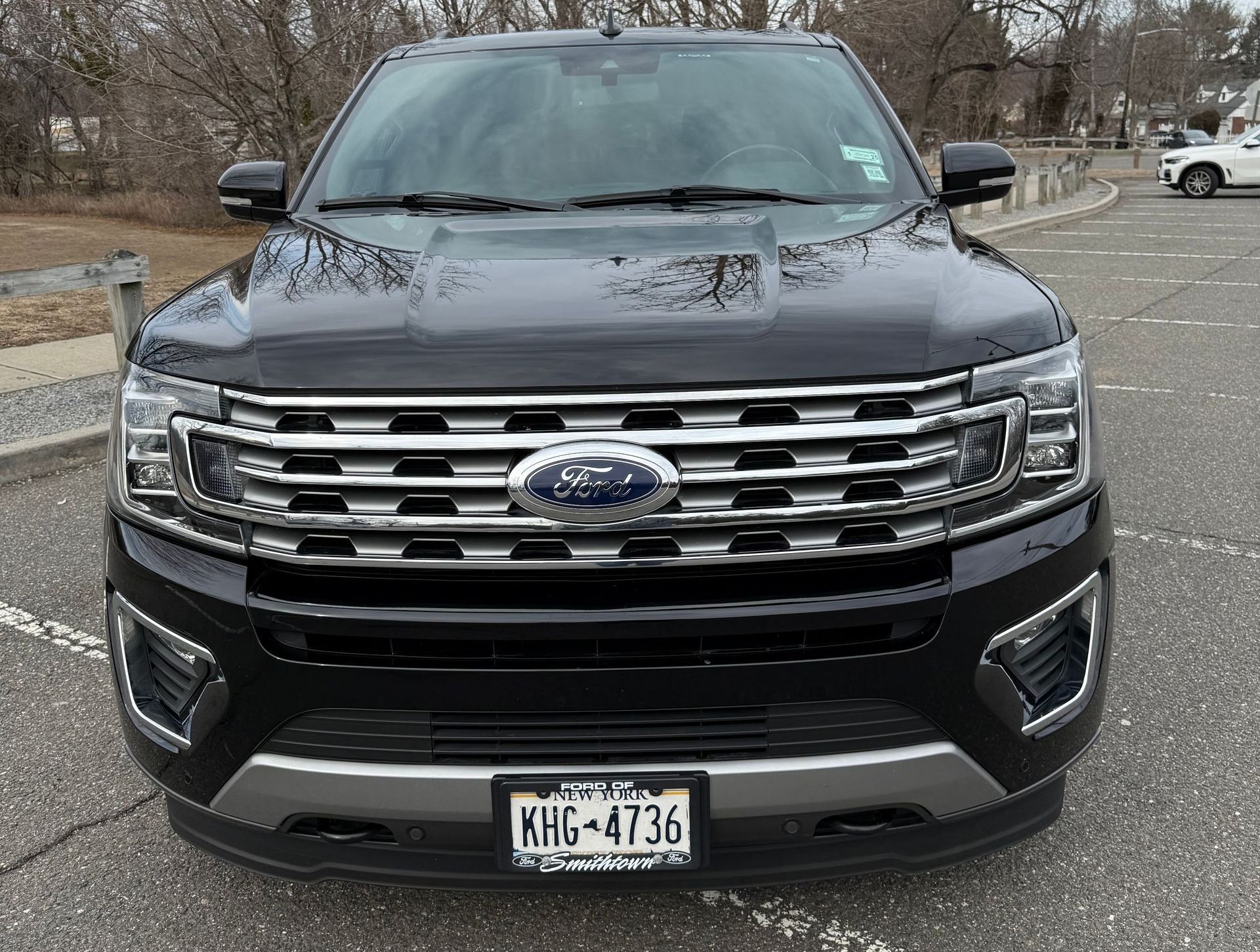A black ford expedition is parked in a parking lot.