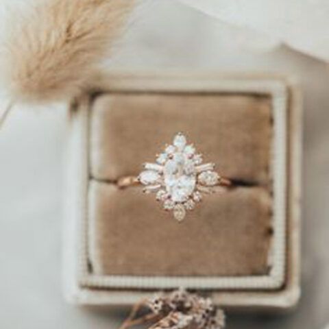 Diamond ring in a beige velvet box with a soft fur accent nearby
