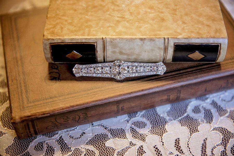 Decorative jeweled barrett with cream and black accents on a lace-covered table