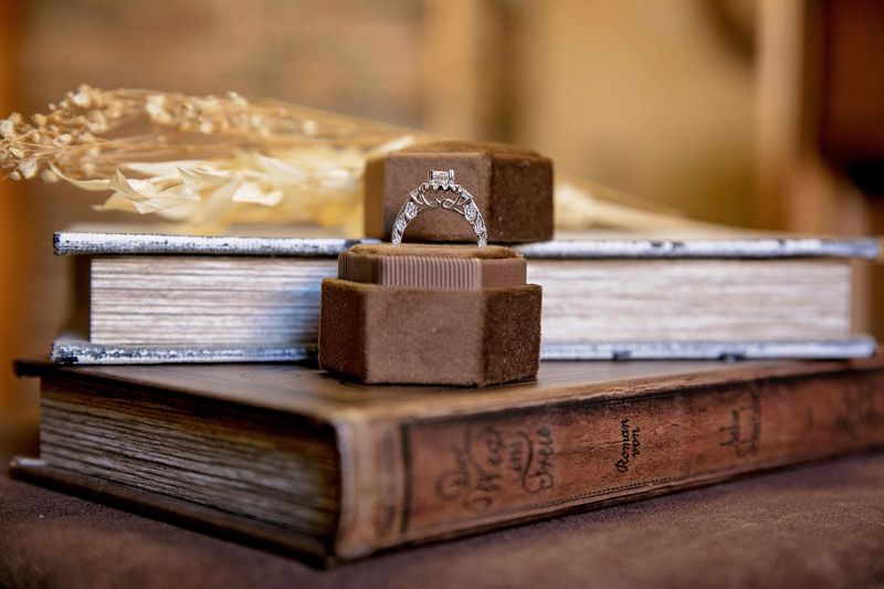 Chocolate-covered candies stacked on closed books, with a gold-wrapped treat in the background
