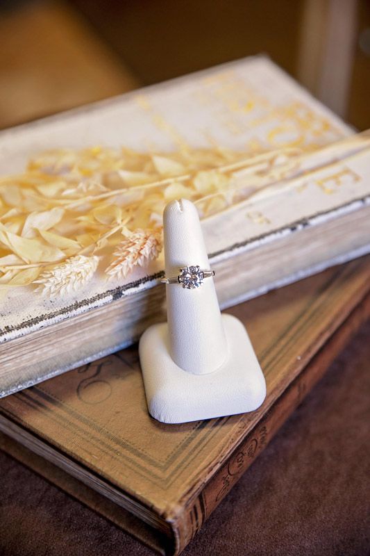 White chess piece on stacked books with shredded paper on top, close-up on wooden table