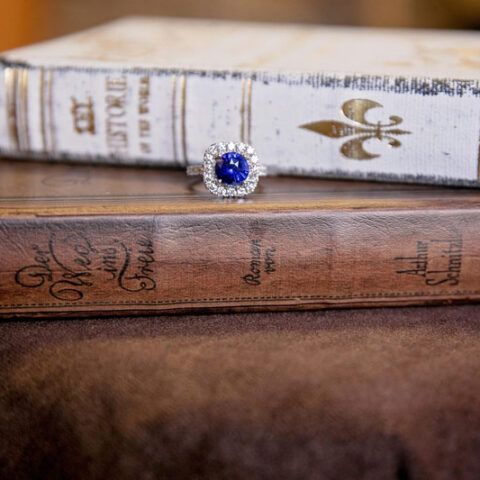 Blue gemstone ring resting on stacked vintage books
