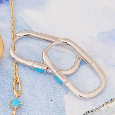 Two silver paperclip-style chain links with blue accents on a soft blue background