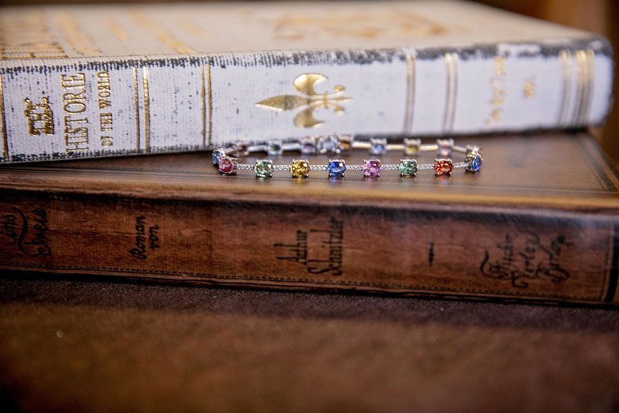 Two stacked vintage books with a rainbow beaded bracelet resting on the lower book