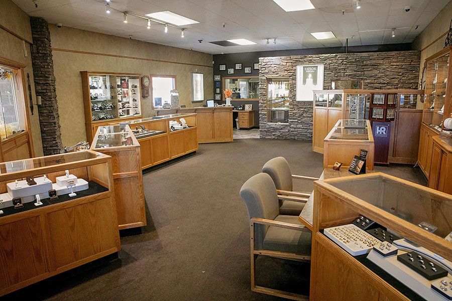 Interior of the store with glass display cases, stone walls, and chairs under ceiling lights