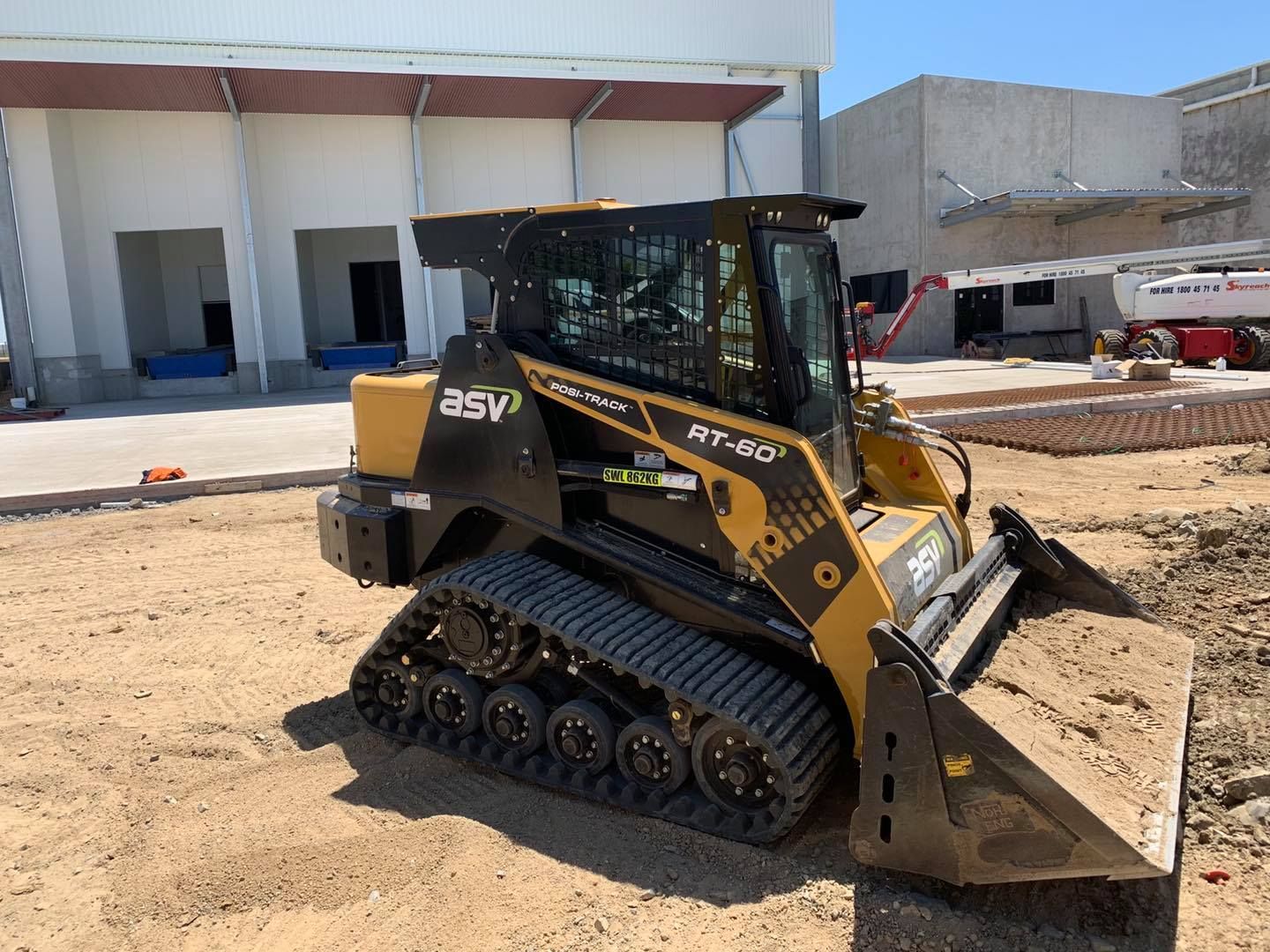 Yellow and Black Asv Rt-50 Compact Track Loader on A Construction Site, with A Raised Front Bucket — Bailey's Bobcat & Excavator Hire In Dumbleton, QLD