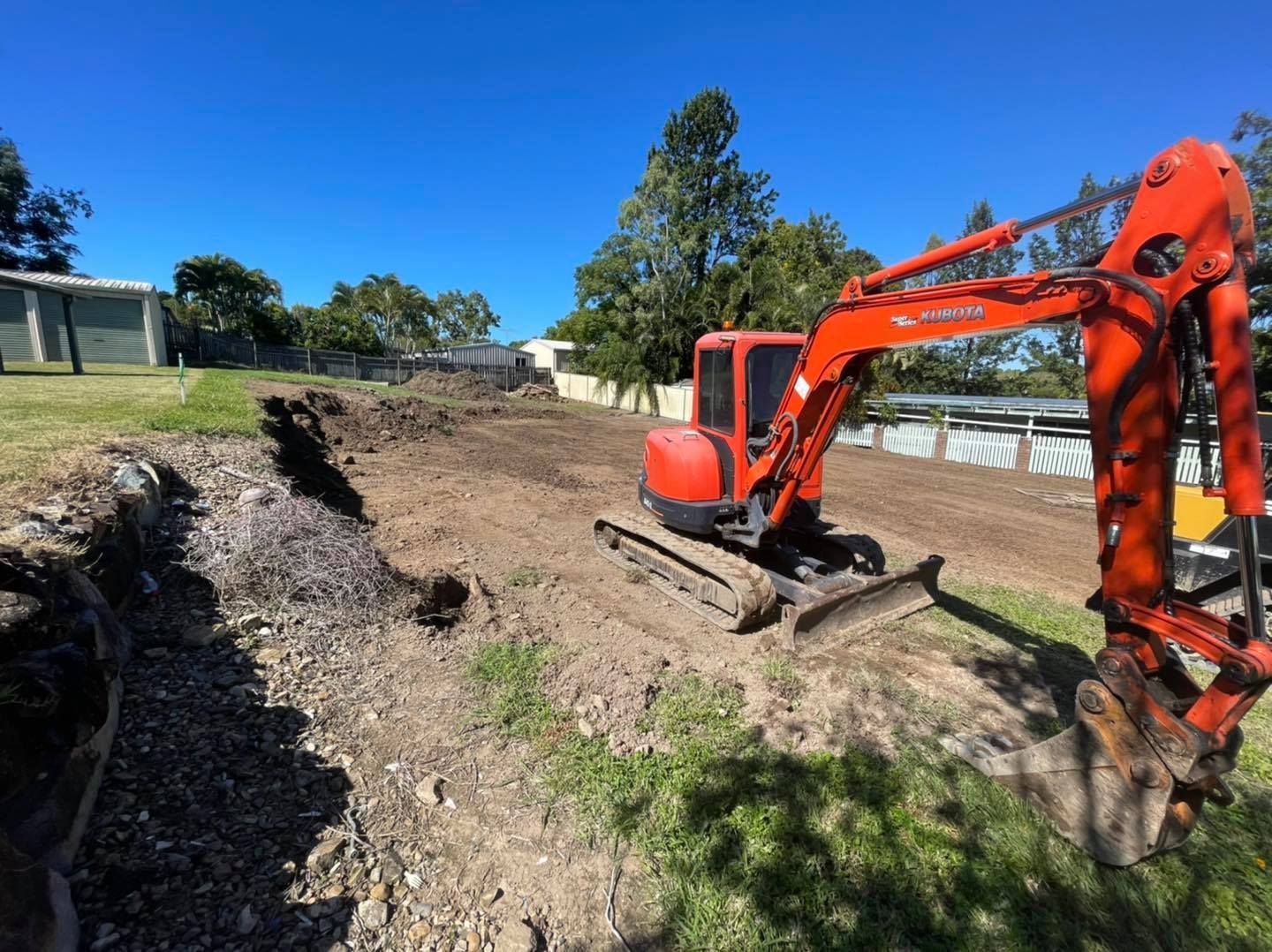 Orange Excavator Digging Dirt on A Construction Site Outdoors on A Sunny Day — Bailey's Bobcat & Excavator Hire In Dumbleton, QLD