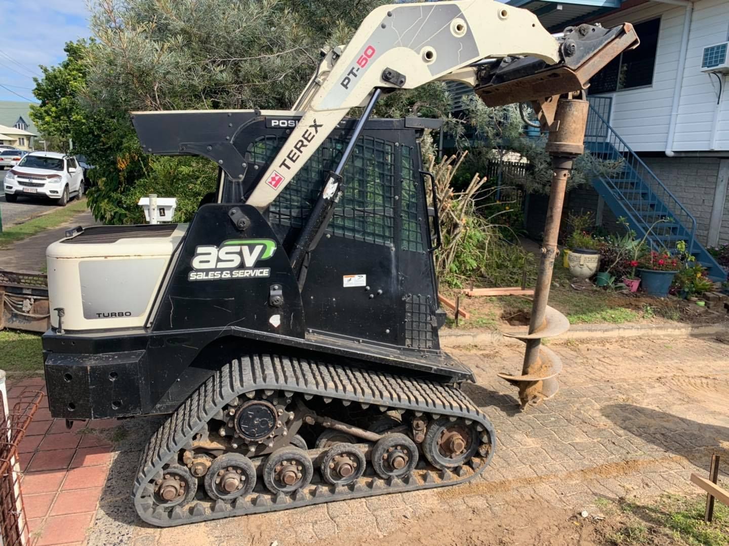 Black and Beige Asv Rt150 Compact Track Loader with Auger Bit Drilling on A Construction Site — Bailey's Bobcat & Excavator Hire In Dumbleton, QLD
